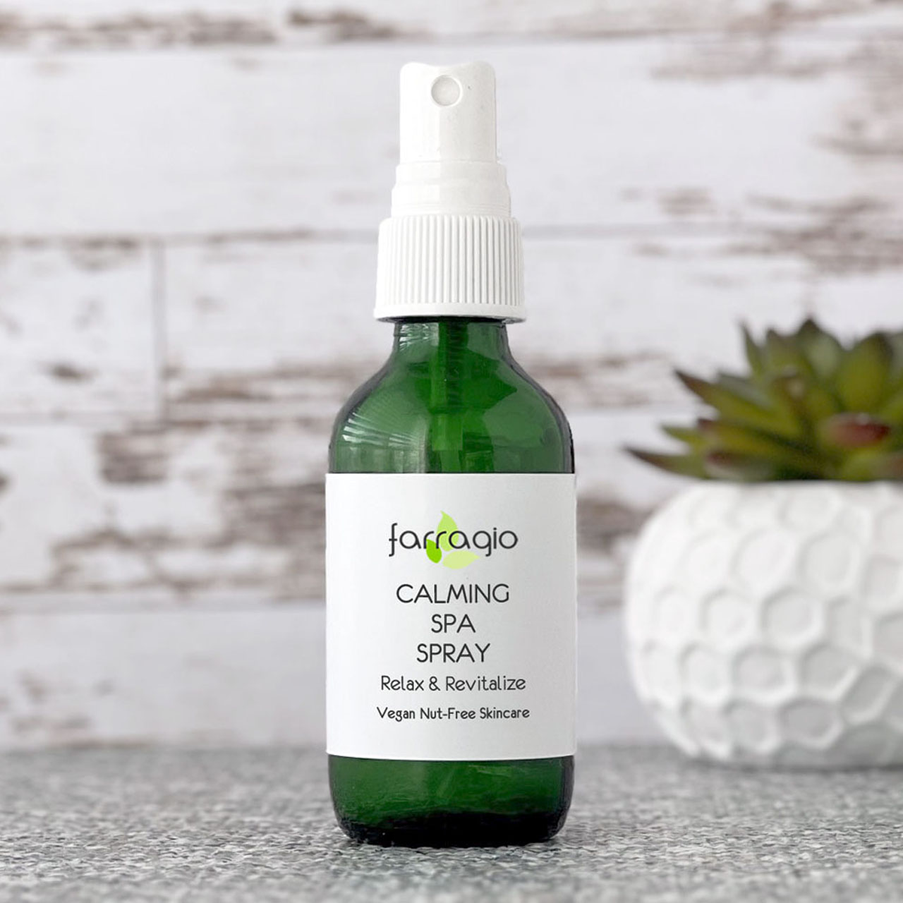 green glass bottle of all natural makeup setting spray